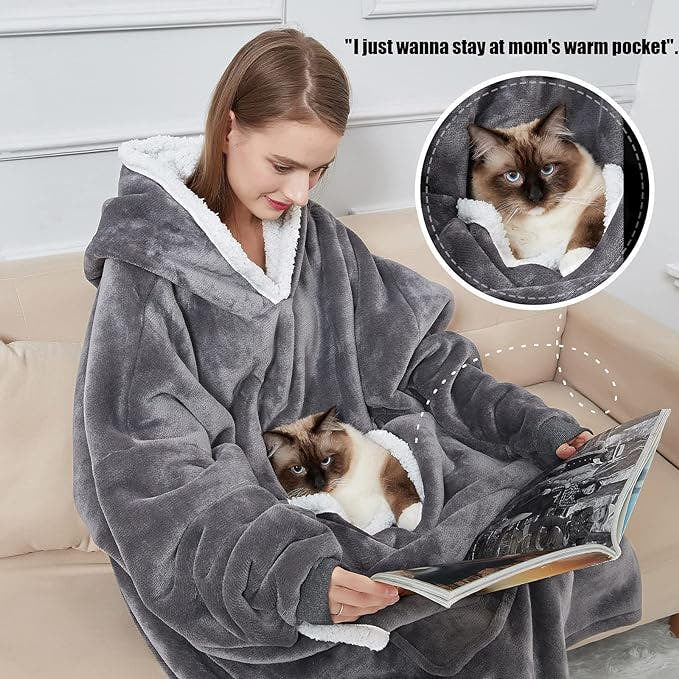 Person wearing a gray hoodie with a cat on a couch, with a humorous inset of a cat in a pocket.